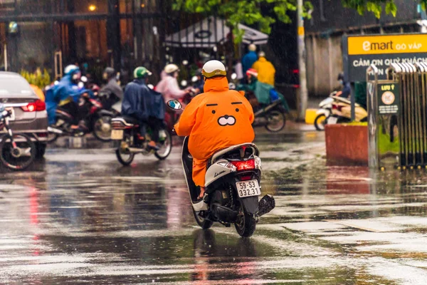 Ho Chi Minh şehri, Vietnam - 08 Ağustos 2020: Yerel halk Emart süpermarketinden alışveriş yapıyor, tıbbi maskeler takıyor, yağmurda motosiklet sürüyor ve Covid-19 salgınında sosyal mesafeyi koruyorlar.