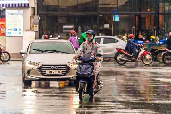 Ho Chi Minh şehri, Vietnam - 08 Ağustos 2020: Yerel halk Emart süpermarketinden alışveriş yapıyor, tıbbi maskeler takıyor, yağmurda motosiklet sürüyor ve Covid-19 salgınında sosyal mesafeyi koruyorlar.