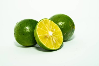 Taze yeşil limon dilimleri beyaz arka planda izole edilmiş. Taze ve gerçek tropikal meyve. İçki ve ürün konsepti