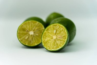 Taze yeşil limon dilimleri beyaz arka planda izole edilmiş. Taze ve gerçek tropikal meyve. İçki ve ürün konsepti