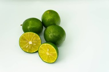 Taze yeşil limon dilimleri beyaz arka planda izole edilmiş. Taze ve gerçek tropikal meyve. İçki ve ürün konsepti
