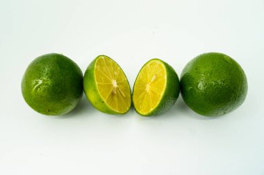 Taze yeşil limon dilimleri beyaz arka planda izole edilmiş. Taze ve gerçek tropikal meyve. İçki ve ürün konsepti