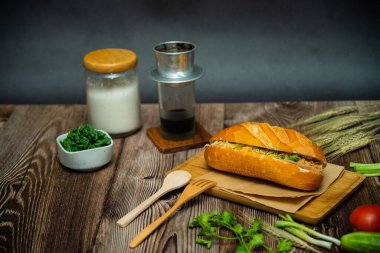 Yemek molasında. Ünlü Vietnam yemekleri Banh mi thit ve sade kahveydir, hammaddeyle doldurulmuş ekmeğin popüler sokak yemekleri: domuz eti, jambon, börek, yumurta ve taze ottur. Tipik Vietnam sandviçi.