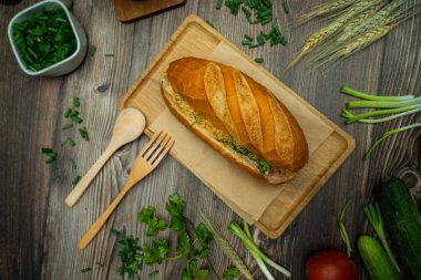 Yemek molasında. Ünlü Vietnam yemekleri Banh mi thit ve sade kahveydir, hammaddeyle doldurulmuş ekmeğin popüler sokak yemekleri: domuz eti, jambon, börek, yumurta ve taze ottur. Tipik Vietnam sandviçi.