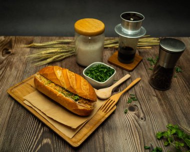 Yemek molasında. Ünlü Vietnam yemekleri Banh mi thit ve sade kahveydir, hammaddeyle doldurulmuş ekmeğin popüler sokak yemekleri: domuz eti, jambon, börek, yumurta ve taze ottur. Tipik Vietnam sandviçi.