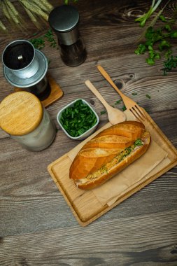 Yemek molasında. Ünlü Vietnam yemekleri Banh mi thit ve sade kahveydir, hammaddeyle doldurulmuş ekmeğin popüler sokak yemekleri: domuz eti, jambon, börek, yumurta ve taze ottur. Tipik Vietnam sandviçi.