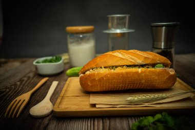 Yemek molasında. Ünlü Vietnam yemekleri Banh mi thit ve sade kahveydir, hammaddeyle doldurulmuş ekmeğin popüler sokak yemekleri: domuz eti, jambon, börek, yumurta ve taze ottur. Tipik Vietnam sandviçi.