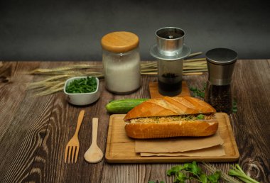 Yemek molasında. Ünlü Vietnam yemekleri Banh mi thit ve sade kahveydir, hammaddeyle doldurulmuş ekmeğin popüler sokak yemekleri: domuz eti, jambon, börek, yumurta ve taze ottur. Tipik Vietnam sandviçi.