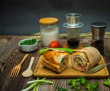 Yemek molasında. Ünlü Vietnam yemekleri Banh mi thit ve sade kahveydir, hammaddeyle doldurulmuş ekmeğin popüler sokak yemekleri: domuz eti, jambon, börek, yumurta ve taze ottur. Tipik Vietnam sandviçi.