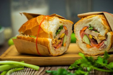 Yemek molasında. Ünlü Vietnam yemekleri Banh mi thit ve sade kahveydir, hammaddeyle doldurulmuş ekmeğin popüler sokak yemekleri: domuz eti, jambon, börek, yumurta ve taze ottur. Tipik Vietnam sandviçi.