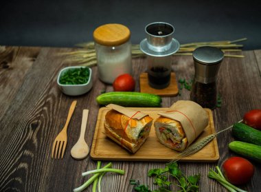 Yemek molasında. Ünlü Vietnam yemekleri Banh mi thit ve sade kahveydir, hammaddeyle doldurulmuş ekmeğin popüler sokak yemekleri: domuz eti, jambon, börek, yumurta ve taze ottur. Tipik Vietnam sandviçi.