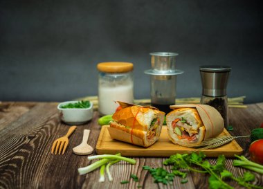 Yemek molasında. Ünlü Vietnam yemekleri Banh mi thit ve sade kahveydir, hammaddeyle doldurulmuş ekmeğin popüler sokak yemekleri: domuz eti, jambon, börek, yumurta ve taze ottur. Tipik Vietnam sandviçi.