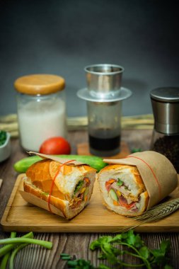 Yemek molasında. Ünlü Vietnam yemekleri Banh mi thit ve sade kahveydir, hammaddeyle doldurulmuş ekmeğin popüler sokak yemekleri: domuz eti, jambon, börek, yumurta ve taze ottur. Tipik Vietnam sandviçi.
