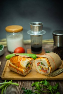 Yemek molasında. Ünlü Vietnam yemekleri Banh mi thit ve sade kahveydir, hammaddeyle doldurulmuş ekmeğin popüler sokak yemekleri: domuz eti, jambon, börek, yumurta ve taze ottur. Tipik Vietnam sandviçi.