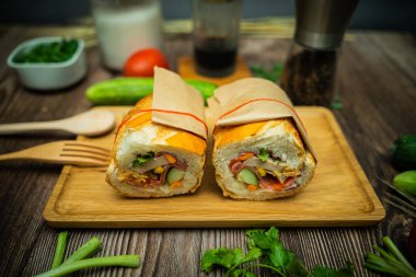 Yemek molasında. Ünlü Vietnam yemekleri Banh mi thit ve sade kahveydir, hammaddeyle doldurulmuş ekmeğin popüler sokak yemekleri: domuz eti, jambon, börek, yumurta ve taze ottur. Tipik Vietnam sandviçi.
