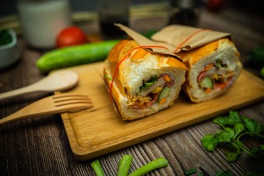 Yemek molasında. Ünlü Vietnam yemekleri Banh mi thit ve sade kahveydir, hammaddeyle doldurulmuş ekmeğin popüler sokak yemekleri: domuz eti, jambon, börek, yumurta ve taze ottur. Tipik Vietnam sandviçi.