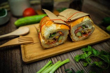 Yemek molasında. Ünlü Vietnam yemekleri Banh mi thit ve sade kahveydir, hammaddeyle doldurulmuş ekmeğin popüler sokak yemekleri: domuz eti, jambon, börek, yumurta ve taze ottur. Tipik Vietnam sandviçi.