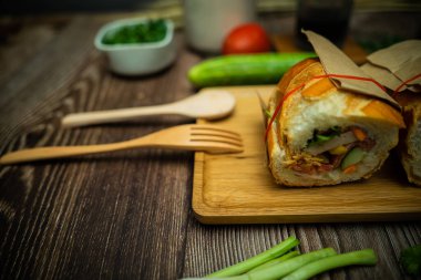 Yemek molasında. Ünlü Vietnam yemekleri Banh mi thit ve sade kahveydir, hammaddeyle doldurulmuş ekmeğin popüler sokak yemekleri: domuz eti, jambon, börek, yumurta ve taze ottur. Tipik Vietnam sandviçi.