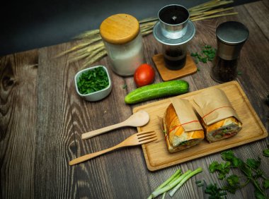 Yemek molasında. Ünlü Vietnam yemekleri Banh mi thit ve sade kahveydir, hammaddeyle doldurulmuş ekmeğin popüler sokak yemekleri: domuz eti, jambon, börek, yumurta ve taze ottur. Tipik Vietnam sandviçi.