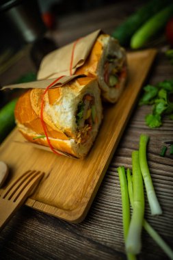 Yemek molasında. Ünlü Vietnam yemekleri Banh mi thit ve sade kahveydir, hammaddeyle doldurulmuş ekmeğin popüler sokak yemekleri: domuz eti, jambon, börek, yumurta ve taze ottur. Tipik Vietnam sandviçi.