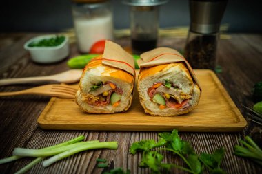 Yemek molasında. Ünlü Vietnam yemekleri Banh mi thit ve sade kahveydir, hammaddeyle doldurulmuş ekmeğin popüler sokak yemekleri: domuz eti, jambon, börek, yumurta ve taze ottur. Tipik Vietnam sandviçi.