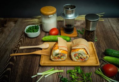 Yemek molasında. Ünlü Vietnam yemekleri Banh mi thit ve sade kahveydir, hammaddeyle doldurulmuş ekmeğin popüler sokak yemekleri: domuz eti, jambon, börek, yumurta ve taze ottur. Tipik Vietnam sandviçi.