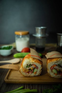 Yemek molasında. Ünlü Vietnam yemekleri Banh mi thit ve sade kahveydir, hammaddeyle doldurulmuş ekmeğin popüler sokak yemekleri: domuz eti, jambon, börek, yumurta ve taze ottur. Tipik Vietnam sandviçi.