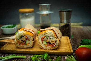 Yemek molasında. Ünlü Vietnam yemekleri Banh mi thit ve sade kahveydir, hammaddeyle doldurulmuş ekmeğin popüler sokak yemekleri: domuz eti, jambon, börek, yumurta ve taze ottur. Tipik Vietnam sandviçi.