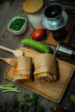 Yemek molasında. Ünlü Vietnam yemekleri Banh mi thit ve sade kahveydir, hammaddeyle doldurulmuş ekmeğin popüler sokak yemekleri: domuz eti, jambon, börek, yumurta ve taze ottur. Tipik Vietnam sandviçi.