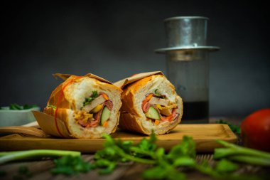 Yemek molasında. Ünlü Vietnam yemekleri Banh mi thit ve sade kahveydir, hammaddeyle doldurulmuş ekmeğin popüler sokak yemekleri: domuz eti, jambon, börek, yumurta ve taze ottur. Tipik Vietnam sandviçi.