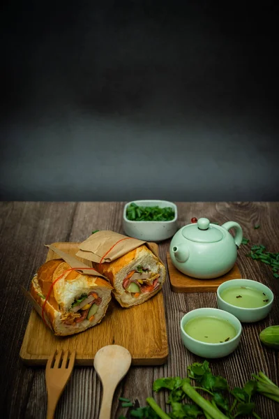 Yemek molasında. Meşhur Vietnam yemekleri Banh mi thit ve sıcak çay, hammaddeyle doldurulmuş ekmeğin popüler sokak yemekleri: domuz eti, jambon, börek, yumurta ve taze ottur. Tipik Vietnam sandviçi.