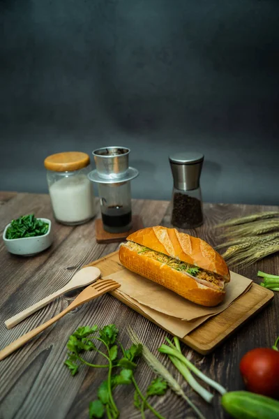 Yemek molasında. Ünlü Vietnam yemekleri Banh mi thit ve sade kahveydir, hammaddeyle doldurulmuş ekmeğin popüler sokak yemekleri: domuz eti, jambon, börek, yumurta ve taze ottur. Tipik Vietnam sandviçi.