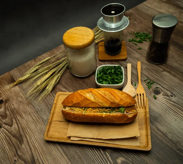 Yemek molasında. Ünlü Vietnam yemekleri Banh mi thit ve sade kahveydir, hammaddeyle doldurulmuş ekmeğin popüler sokak yemekleri: domuz eti, jambon, börek, yumurta ve taze ottur. Tipik Vietnam sandviçi.