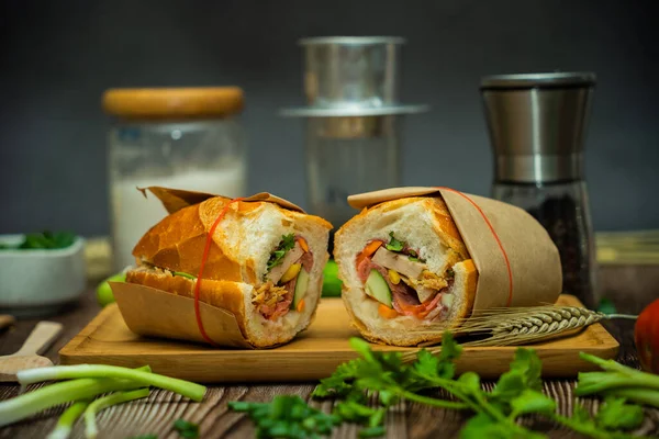 Yemek molasında. Ünlü Vietnam yemekleri Banh mi thit ve sade kahveydir, hammaddeyle doldurulmuş ekmeğin popüler sokak yemekleri: domuz eti, jambon, börek, yumurta ve taze ottur. Tipik Vietnam sandviçi.