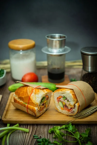 Yemek molasında. Ünlü Vietnam yemekleri Banh mi thit ve sade kahveydir, hammaddeyle doldurulmuş ekmeğin popüler sokak yemekleri: domuz eti, jambon, börek, yumurta ve taze ottur. Tipik Vietnam sandviçi.