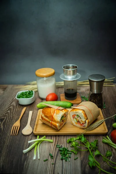 Yemek molasında. Ünlü Vietnam yemekleri Banh mi thit ve sade kahveydir, hammaddeyle doldurulmuş ekmeğin popüler sokak yemekleri: domuz eti, jambon, börek, yumurta ve taze ottur. Tipik Vietnam sandviçi.