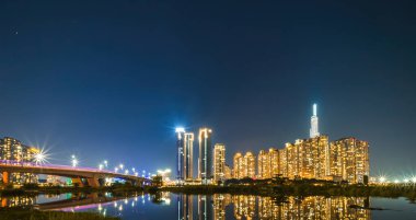 Landmark 81 'deki Panorama gece görüşü, Ho Chi Minh City, Vietnam ve Thu Thiem Köprüsü' nde inşaat binaları olan süper uzun bir gökdelendir. İş ve manzara kavramı.