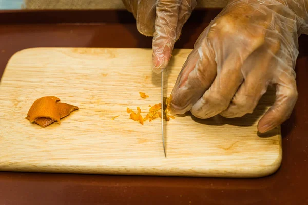 Zbliżenie Kobiecej Ręki Nożem Pociętym Wysuszoną Skórką Mandarynki Drewnianej Desce — Zdjęcie stockowe