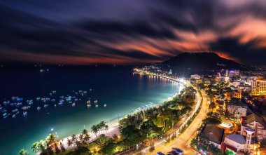 Yukarıdan Vung Tau panoramik kıyı manzarası, dalgalar, kıyı şeridi, sokaklar, hindistan cevizi ağaçları ve Vietnam 'daki Tao Phung dağı. Geceleri uzun pozlu fotoğrafçılık.