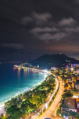 Yukarıdan Vung Tau panoramik kıyı manzarası, dalgalar, kıyı şeridi, sokaklar, hindistan cevizi ağaçları ve Vietnam 'daki Tao Phung dağı. Geceleri uzun pozlu fotoğrafçılık.