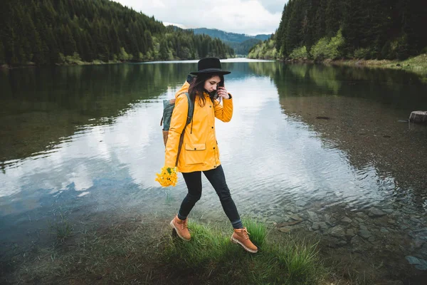 Lächelndes Hipstermädchen Mit Hut Rucksack Und Gelber Jacke Das Vorsichtig — Stockfoto