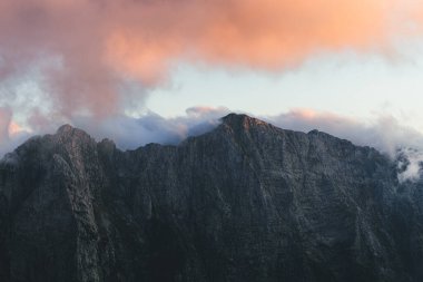 Renkli günbatımına ya da gündoğumuna karşı kayalık dağların alçak açılı görüntüsü. Mangart Geçidi 'nin tepesindeki dağ manzarası, Julian Alps, Slovenya