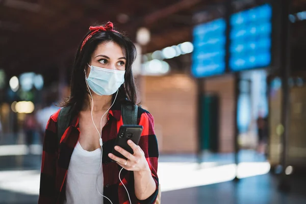 Mujer Joven Con Máscara Médica Protectora Pie Mirando Teléfono Aeropuerto — Foto de Stock