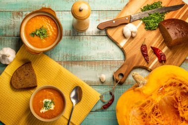 Vejetaryen sonbahar balkabağı kremalı çorba. Ahşap bir masada baharatlı balkabağı çorbası