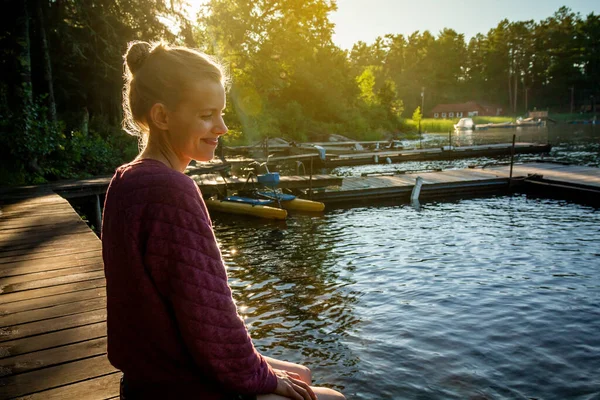 Rıhtımda oturan kadın, Voyageurs Ulusal Parkı, Minnesota 'daki Kabetogama Gölü' ne bakıyor.