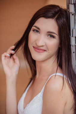 Güzel esmer bir kızın yakın plan portresi, kameraya bakıyor, gülümsüyor ve gülüyor. Mutlu aile bir karavanda seyahat eder, balayını kutlar, doğada kamp yapar ve piknik yapar.