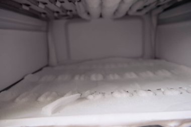 Kirli, yıkanmamış ve buzlu buzdolabı. İhlal ve hijyenik ve epidemiyolojik standartlara uymama, buzdolabı ve dondurucudaki yiyeceklerin içeriğine karşı sorumsuz tavır..