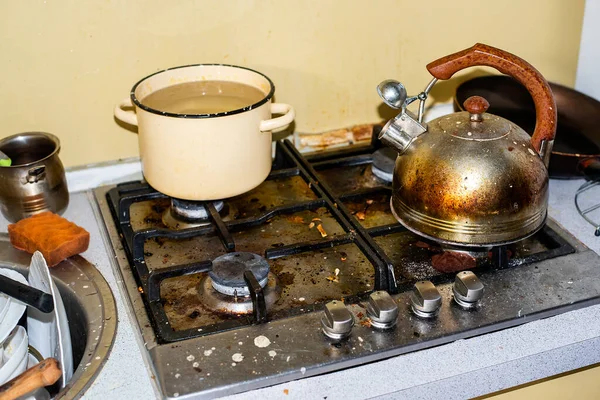 Pis ve pis bir mutfak, yağlı bir soba, lavaboda bir dağ dolusu yıkanmamış bulaşık. Sağlıksız koşullar, evin dağınıklığı. Çaydanlık ve pirzolalar yanmış ve plaka takılmış.