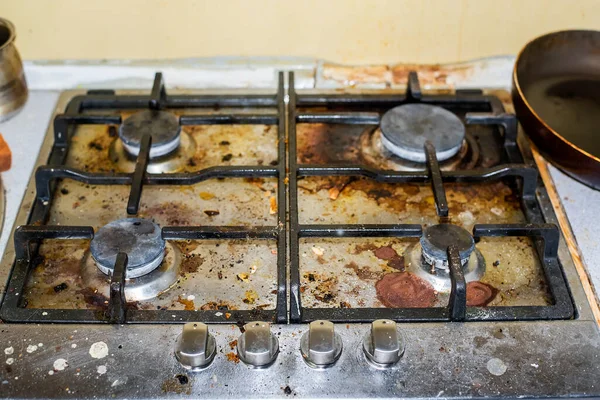 The gas stove is covered in grease and stains of dirt. Traces of spilled coffee. Unsanitary conditions and a mess in the kitchen. Cleaning company will cope with pollution, means for cleaning fat