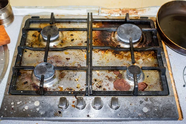 The gas stove is covered in grease and stains of dirt. Traces of spilled coffee. Unsanitary conditions and a mess in the kitchen. Cleaning company will cope with pollution, means for cleaning fat